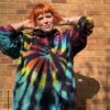 A woman wearing a hoody with a tie dye black and rainbow swirl in the centre