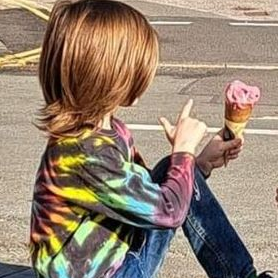 picture of little boy wearing a long sleeve tie dye t-shirt with a b lack and rainbow swirl on