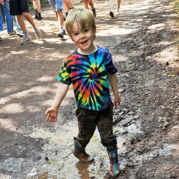 picture of a little boy wearing a tie dye t-shirt with a black and rainbow swirl on