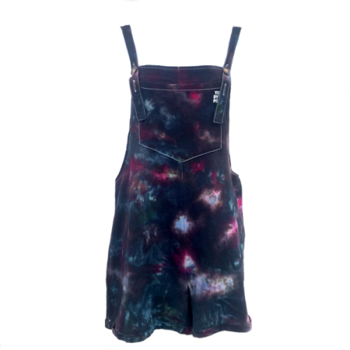 short dungarees ice dyed with black, green and purple to create a nebula effect.