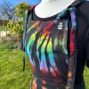 pinafore dress tie dyed in a black rainbow colourway with red, orange, yellow, green, turquoise and purple slashed through with black