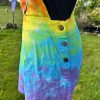 pinafore dress tie dyed in a rainbow colourway with red, orange, yellow, green, turquoise and purple.