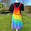 pinafore dress tie dyed in a rainbow colourway with red, orange, yellow, green, turquoise and purple.
