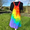 pinafore dress tie dyed in a rainbow colourway with red, orange, yellow, green, turquoise and purple.