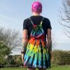 pinafore dress tie dyed in a black rainbow colourway with red, orange, yellow, green, turquoise and purple slashed through with black