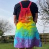 pinafore dress tie dyed in a rainbow colourway with red, orange, yellow, green, turquoise and purple.